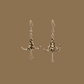 Black and gold origami lily earrings with a floral and geometric pattern on a beige background