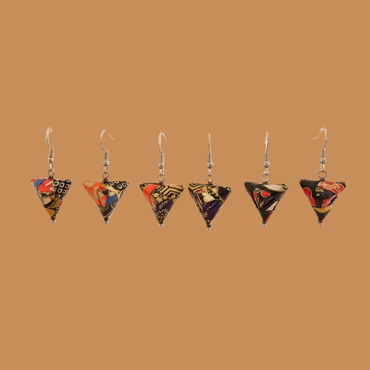 3 pairs various black geometric origami earrings with a floral pattern on a beige background