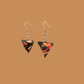 Black and Read triangle geometric origami earrings with a floral and geometric pattern on a beige background