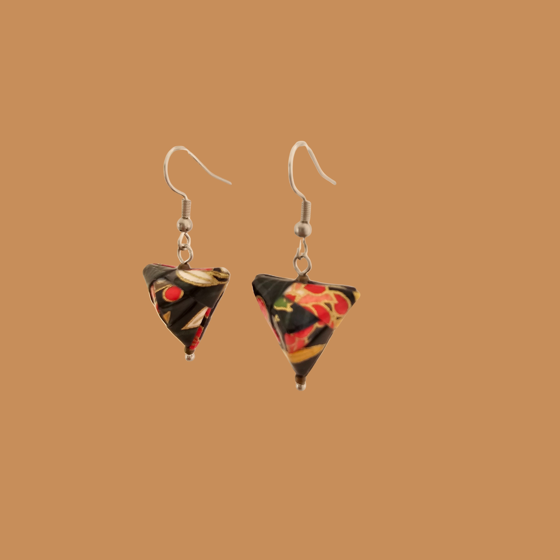 Black and Read triangle geometric origami earrings with a floral and geometric pattern on a beige background