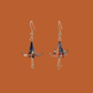 A pair of blue, purple, orange origami lily earrings with a floral and geometric pattern on an orange background