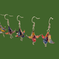 Three pairs of blue and purple origami lily earrings with a floral and geometric pattern on a beige background