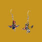 A pair of blue origami lily earrings with a floral and geometric pattern on a yellow background