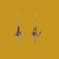 A pair of blue origami lily earrings with a floral and geometric pattern on a yellow background