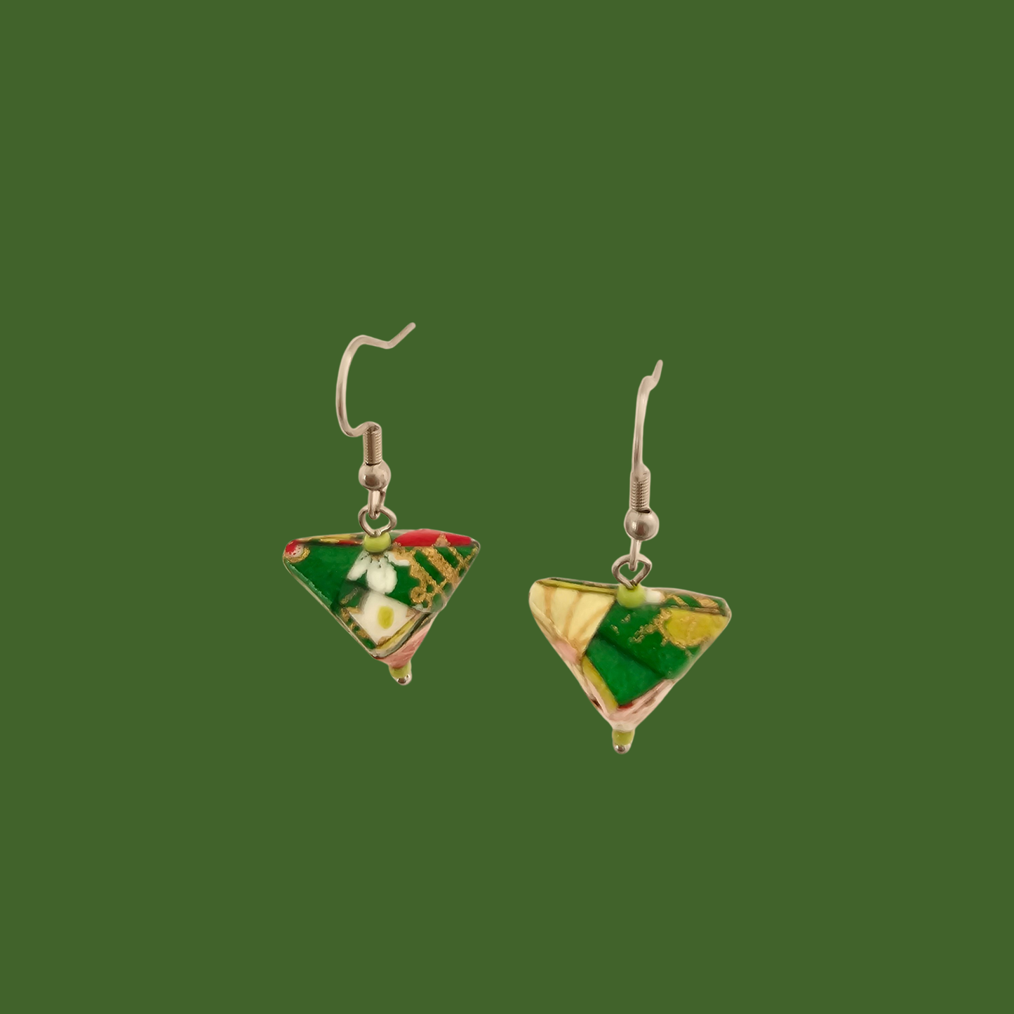 Green, pink, and gold geometric origami earrings with a floral pattern on a green background.