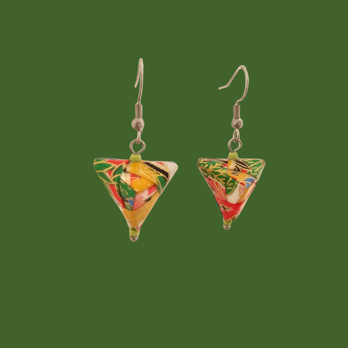 Green, red, and gold geometric origami earrings with a floral pattern on a green background.