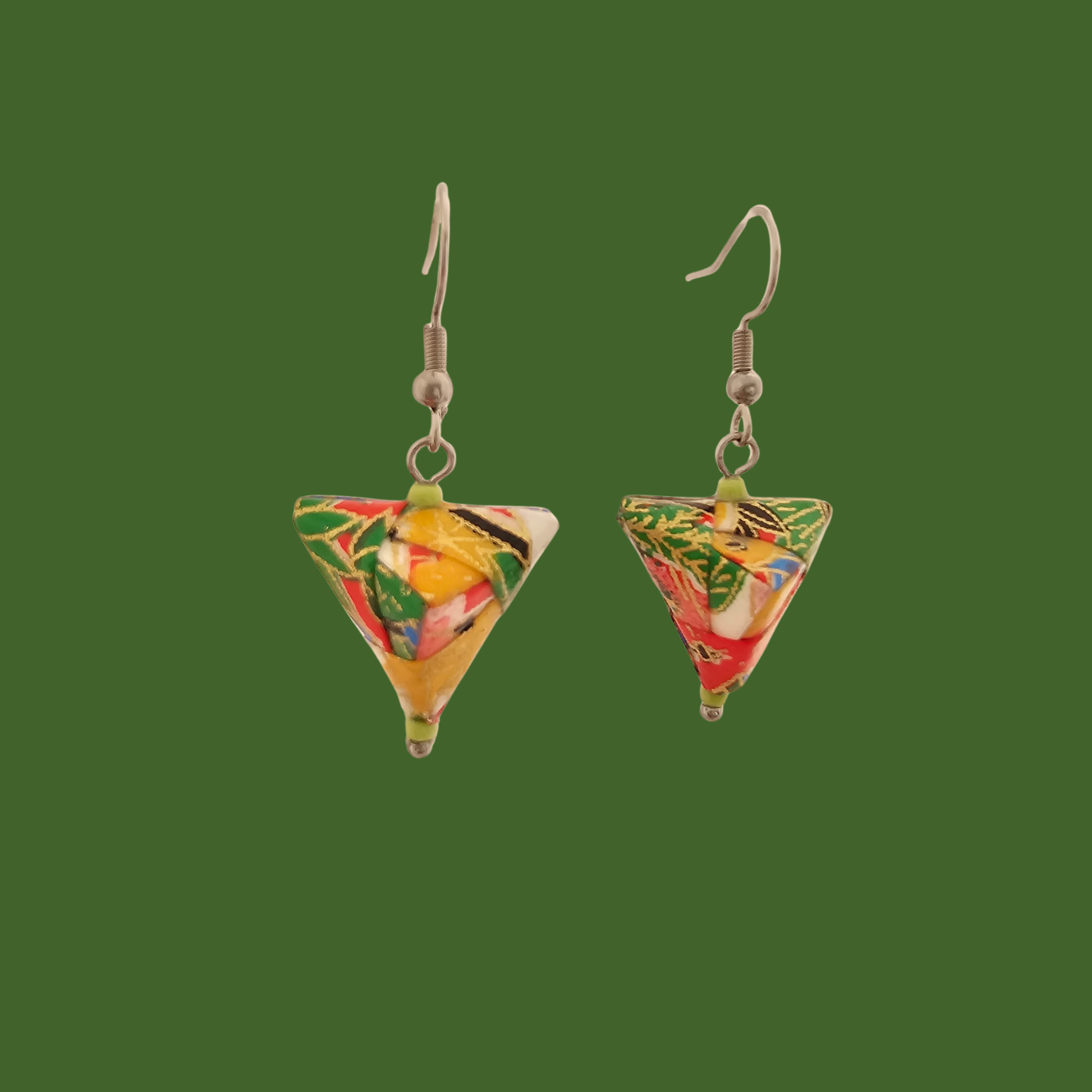 Green, red, and gold geometric origami earrings with a floral pattern on a green background.