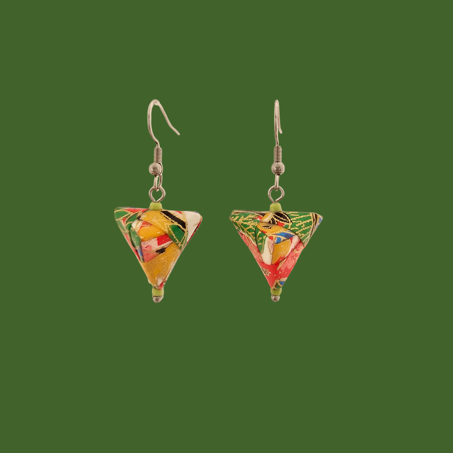Green, red, and gold geometric origami earrings with a floral pattern on a green background.