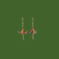 A pair of blue, purple, yellow origami lily earrings with a floral and geometric pattern on a green background