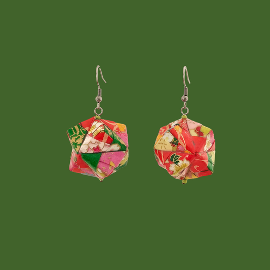 Pair of pink and green geometric origami earrings with a floral pattern on a green background.