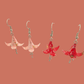 Two Pairs of Pink and red origami lily earrings with a floral and geometric pattern on a beige background
