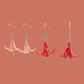 Two Pairs of Pink and red origami lily earrings with a floral and geometric pattern on a beige background