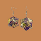 Pair of purple and gold geometric origami earrings with a floral pattern on a beige background.