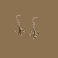 White, black and gold origami lily earrings with a floral and geometric pattern on a beige background