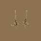 Black and gold origami lily earrings with a floral and geometric pattern on a beige background