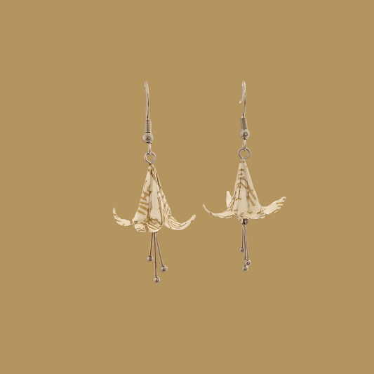 White and gold origami lily earrings with a floral and geometric pattern on a beige background