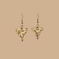 White and Gold triangle geometric origami earrings with a floral and geometric pattern on a beige background