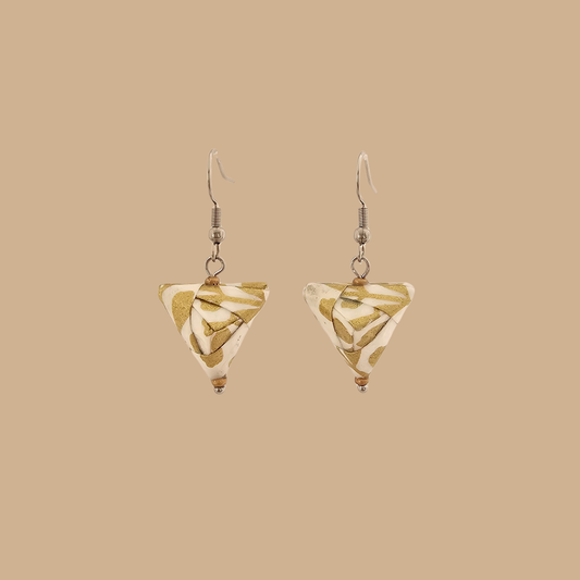 White and Gold triangle geometric origami earrings with a floral and geometric pattern on a beige background