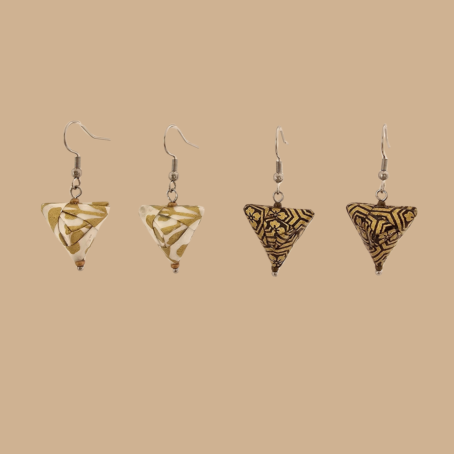 White and Gold triangle geometric origami earrings with a floral and geometric pattern on a beige background