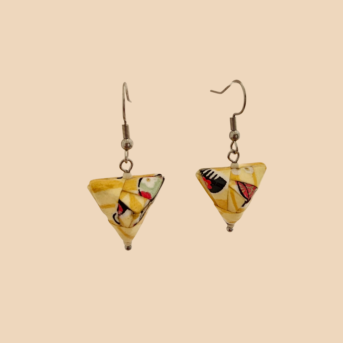 Yellow geometric origami earrings with a floral pattern on a beige background